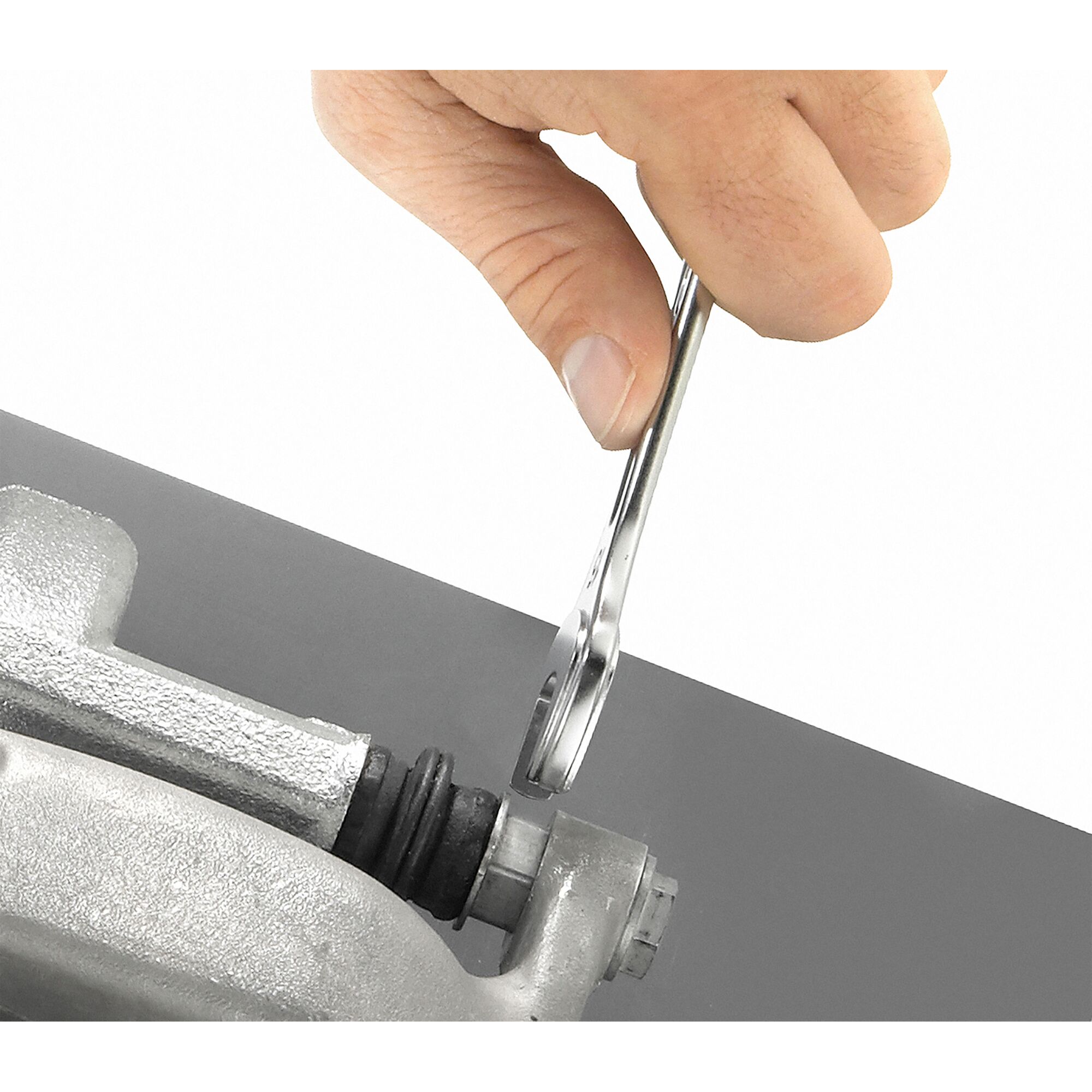 Facom 440_25 combination wrench being used to tighten a bolt on a metal part, close-up view.